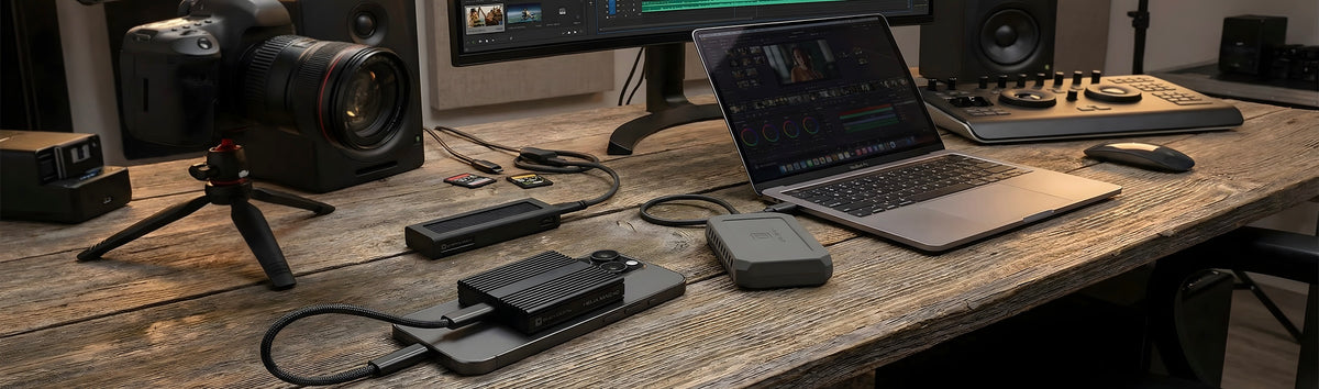 Oyen Digital portable SSDs and a Helix Mag docking drive on an editing desk beside a MacBook Pro and colour-grading panel